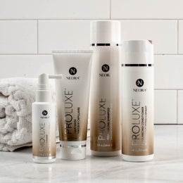 Image of the ProLuxe Hair Care System, including Scalp Treatment, Hair Mask, Conditioner and Shampoo, in a bathroom setting.
