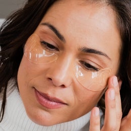 Image of a woman applying the Eye-V Moisture Boost Hydrogel Patches underneath her eyes.