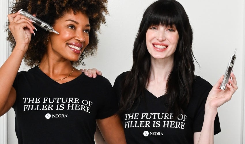 Two women wearing black “The Future of Filler is Here” shirts hold tubes of Neo-FILLER next to each other.