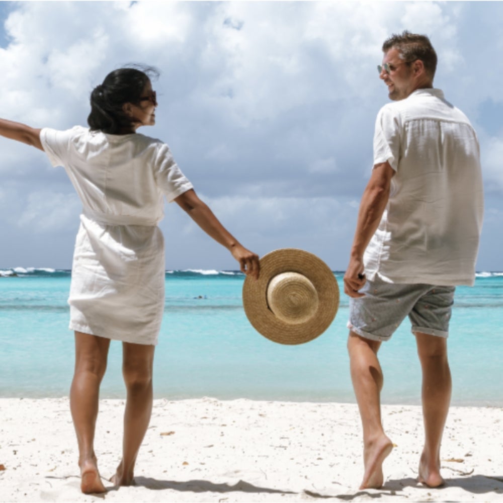 A couple enjoying the beach by the water.