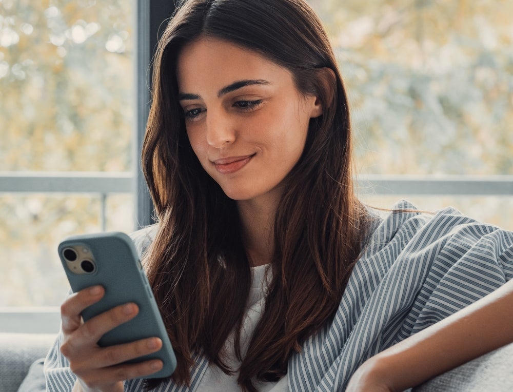 A seated woman looking at her phone.