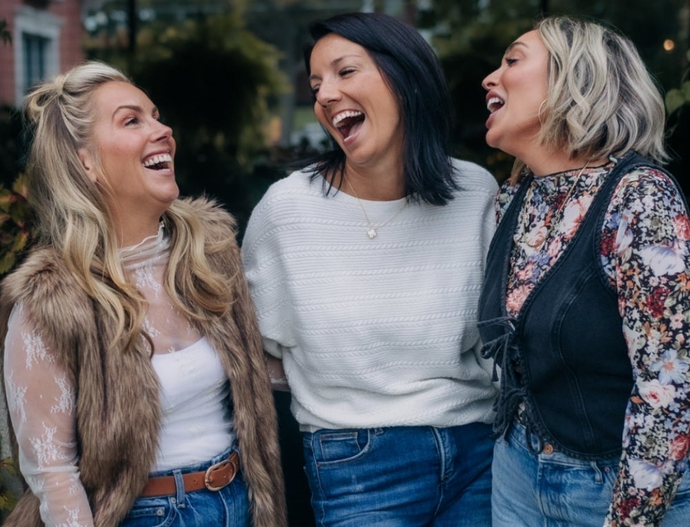 A group of three female Brand Partners laughing together.