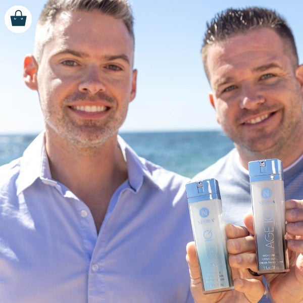 A pair of men holding bottles of Age IQ Day & Night Cream.