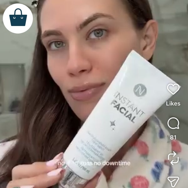 A woman holding a bottle of Neora’s Instant Facial.