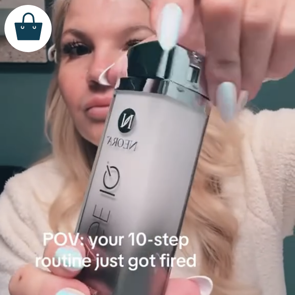 A woman holding a bottle of Age IQ Night Cream.