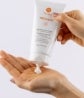 A person squeezes a tube of Prolistic Lotion into their hand.