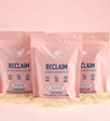 Three bags of RECLAIM resting on a pile of the RECLAIM product powder.