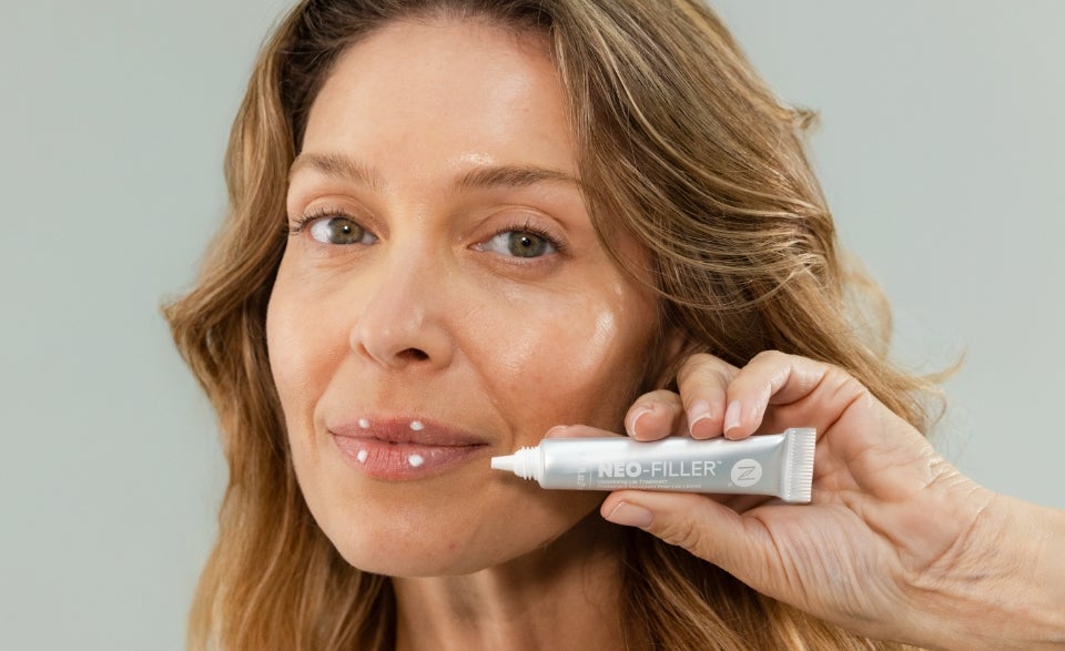 A thumbnail for the How To Use video. Featured is a woman holding the Neo-FILLER Face & Lip Contour Duo products in front of her face.