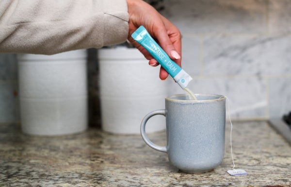 Lifestyle shot of NeoraFit Cleanse + Calm Nightly Gentle Cleanse Powder being poured into a cup.