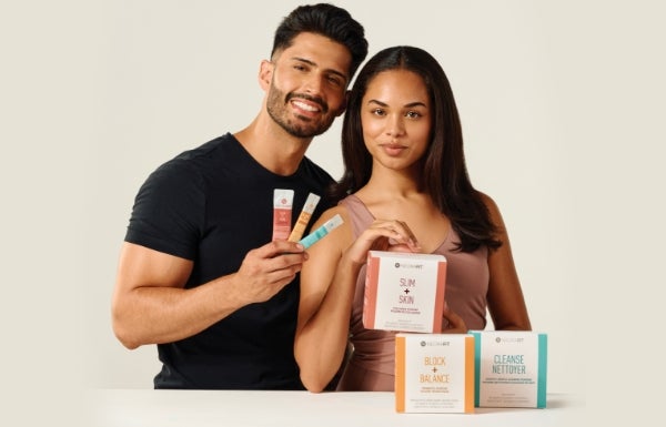 A man and woman pose with NeoraFit products in front of them.