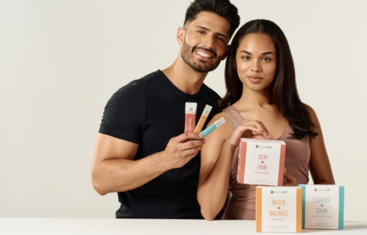 A man and woman smiling behind a row of NeoraFit™ boxes.