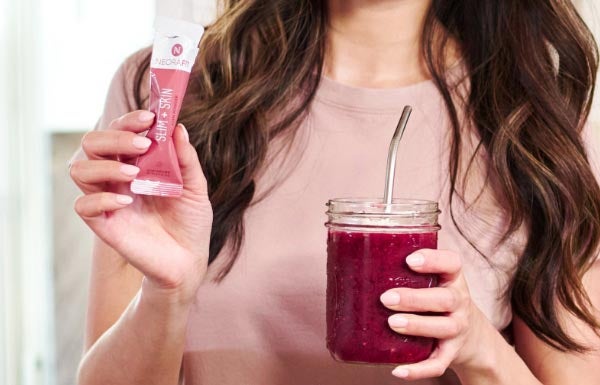 Lifestyle shot of a woman making a drink with the NeoraFit™️ Slim & Skin.