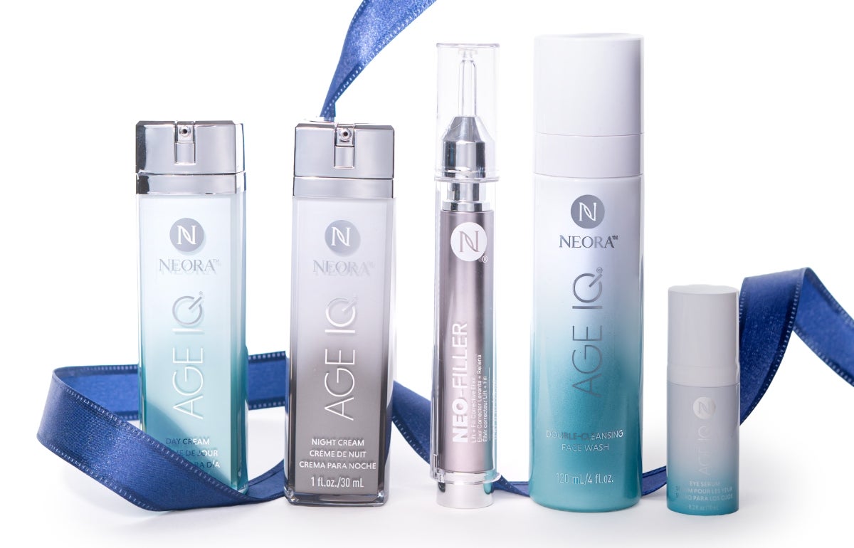 A bundle of Neora skincare products, which include Neo-FILLER, Age IQ Eye Serum, Age IQ Day & Night Creams, and Double-Cleansing Face Wash, surrounded by blue ribbon and a blue Neora branded velvet bag.