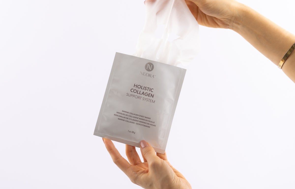 A woman pulling Marine Collagen Sheet Masks out of its packaging.