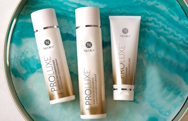 Neora’a ProLuxe Hair Care System featuring ProLuze Rebalancing Shampoo and Conditioner and ProLuxe Hair Mask laying on a ceramic plate