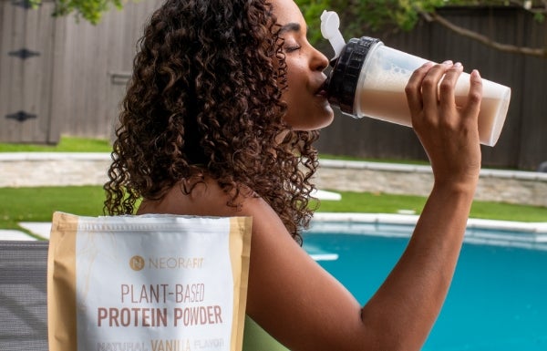 A woman drinking a protein shake made from the Plant-Based Protein Powder.