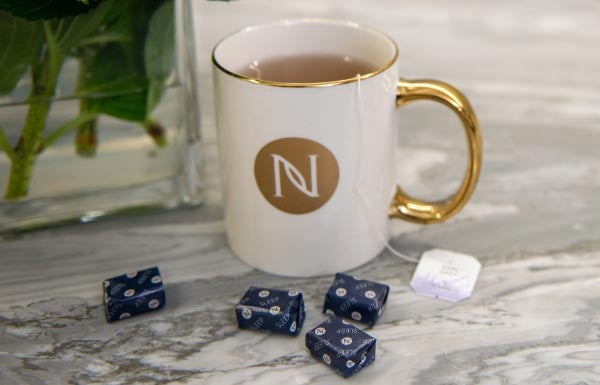 Lifestyle shot of Sleep+ Wellness Chews next to a cup with tea in it.