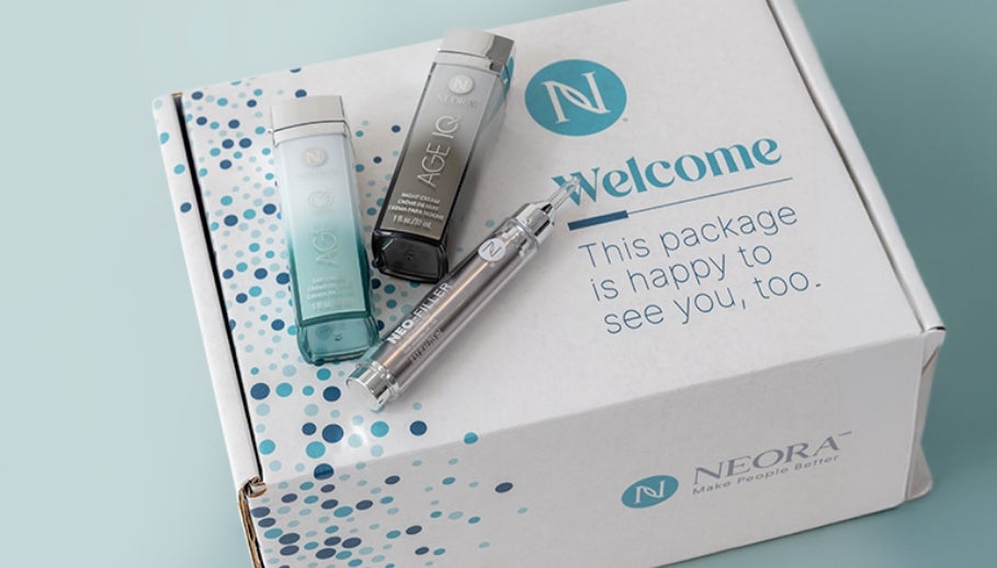 A Neora packaging box with various Neora skincare products on top.
