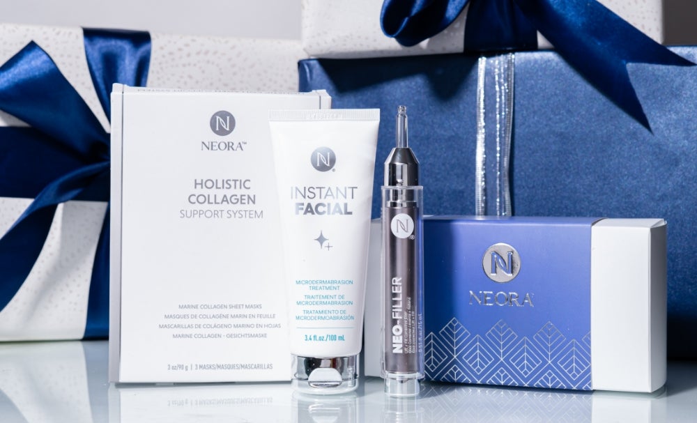 A bundle of Neora skincare products, which include Instant Facial, Neo-FILLER, and a box of Marine Collagen Sheet Masks, surrounded by festive gift boxes.