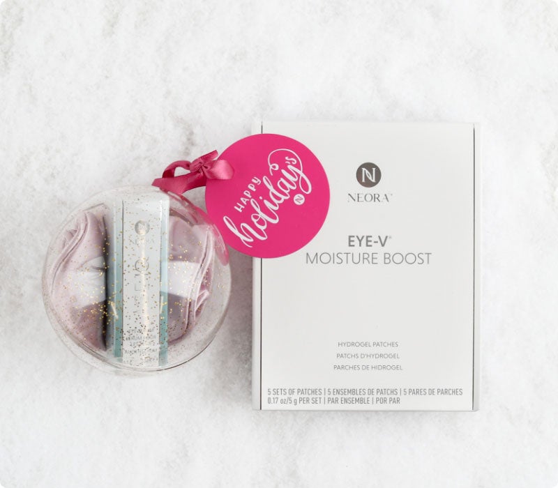 Neora’s hottest holiday must-have, the All Eyes on You Set, which includes Age IQ® Eye Serum, Eye-V™ Moisture Boost Hydrogel Patches and FREE Eye Mask laying on a bed of snow.