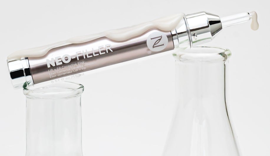 A tube of Neo-Filler resting on beakers.