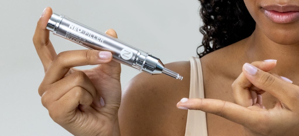 A woman applying a droplet of Neo-FILLER to her finger.