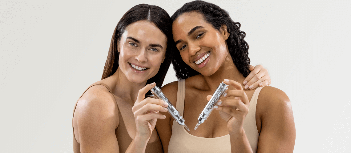 Two smiling woman holding Neo-FILLER tubes.
