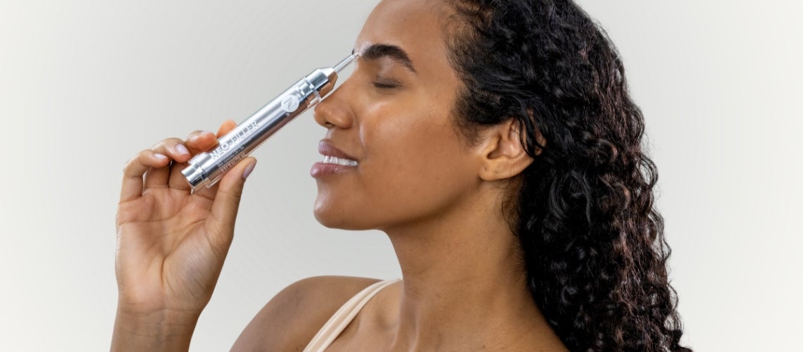 A woman holding a Neo-FILLER tube on her nose.