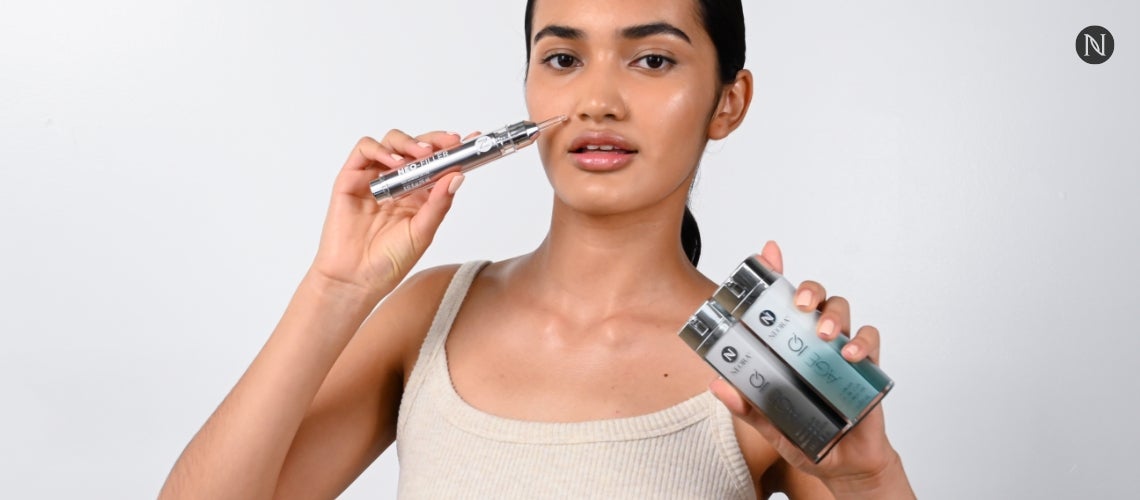 A woman holding up the Fill, Lift & Glow Set.