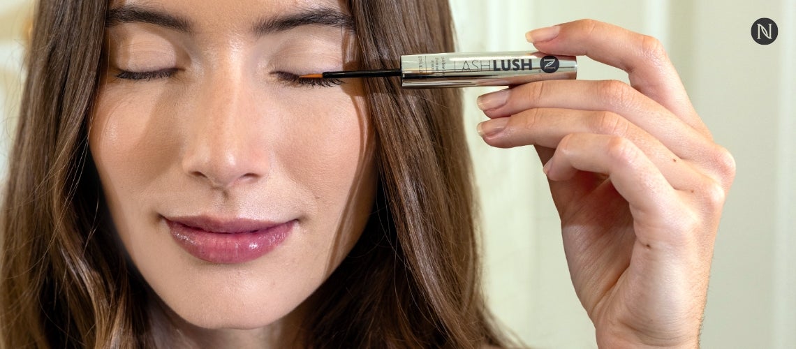 A woman applying LashLush to her eyelashes.