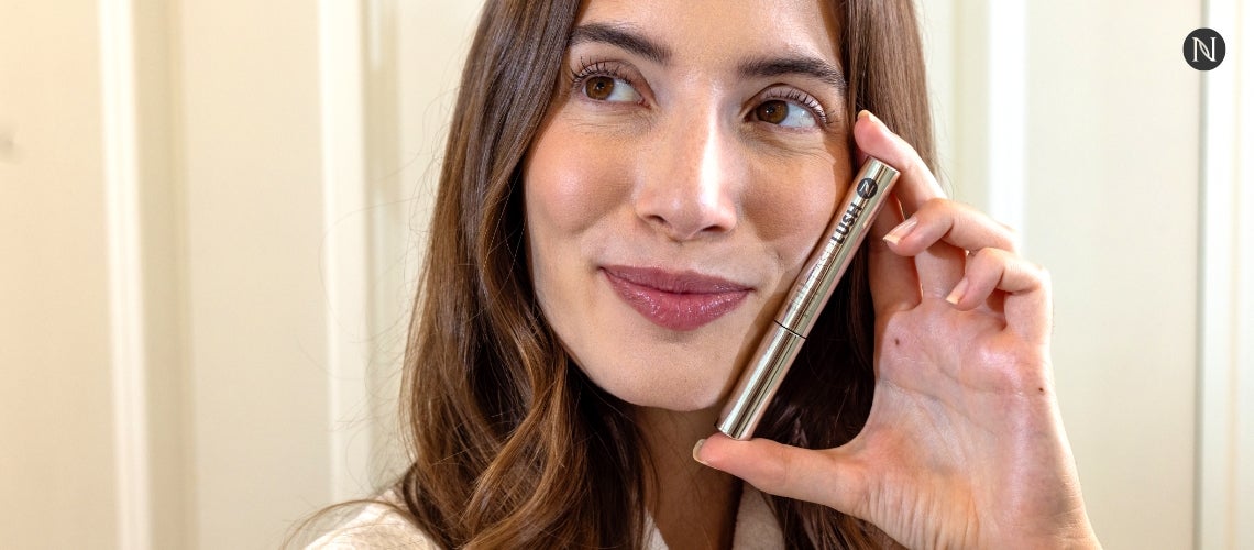 A woman holding LashLush to her face.