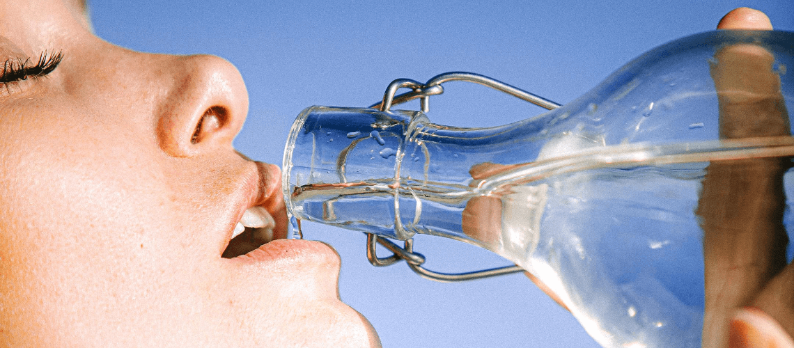 A person drinking from a bottle of water.