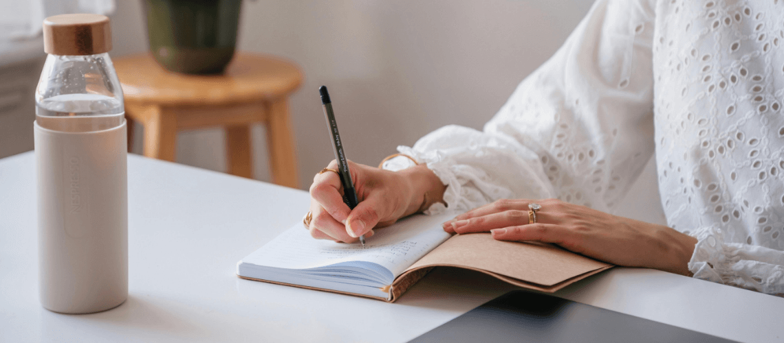 A woman writing notes in their journal.