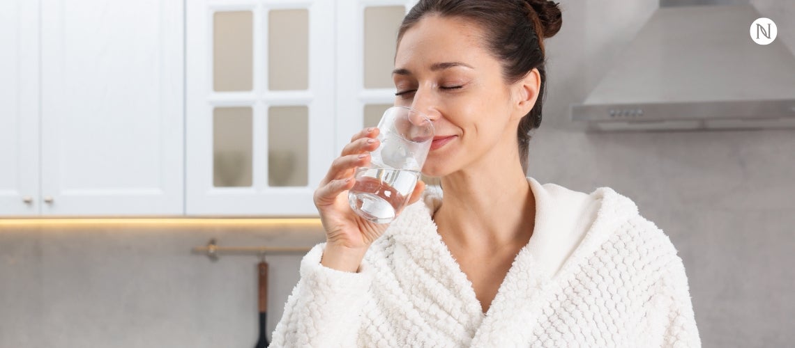 A relaxed woman drinking water.