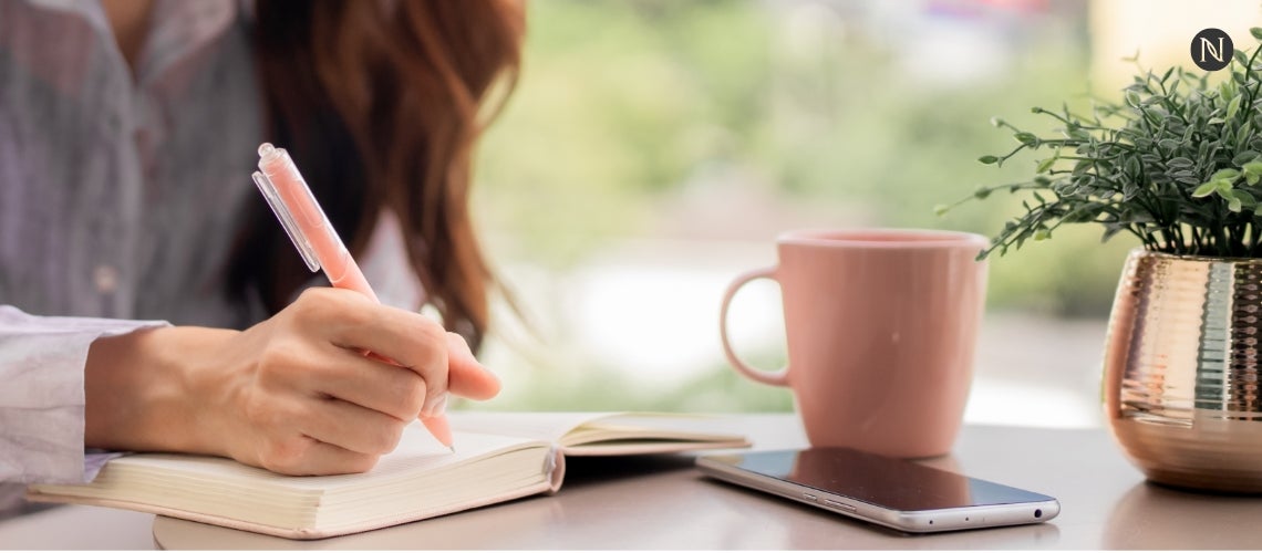 A woman writing in her notebook.