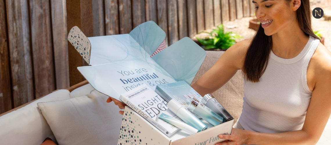 A woman excited about the resources and products in her Neora box.