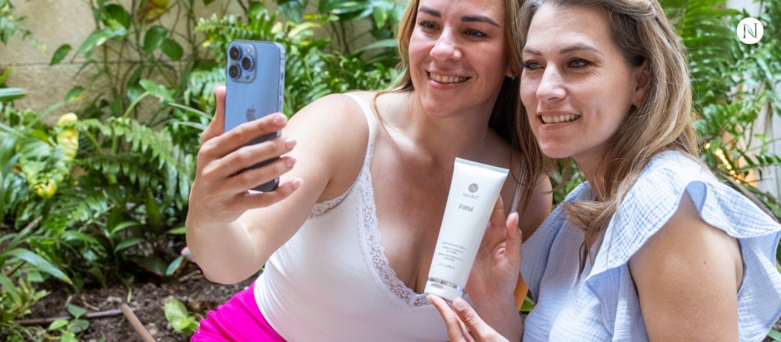 A pair of women taking a selfie with a Neora product.
