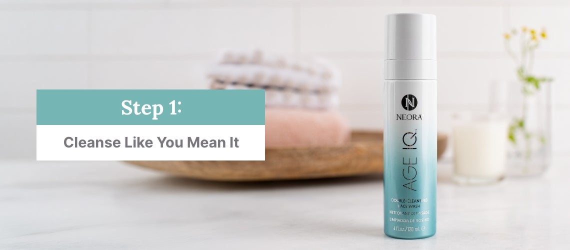 Step 1: Cleanse Like You Mean It. Featured is a bottle of Neora Double-Cleansing Face Wash on a bathroom counter.