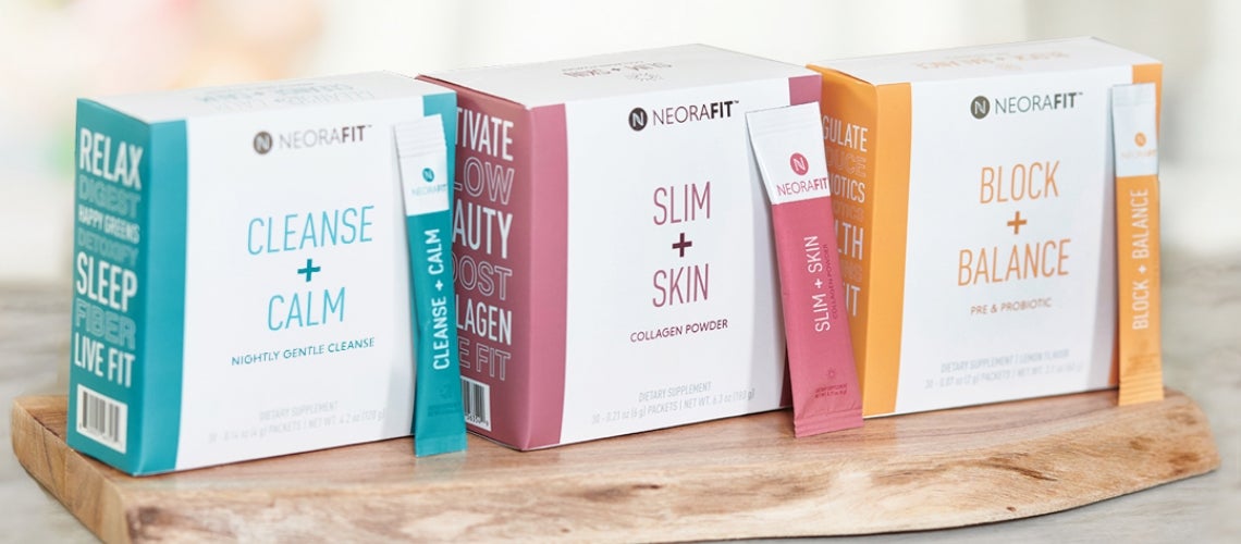 Three NeoraFit wellness boxes on a wooden tray: Cleanse + Calm (turquoise), Slim + Skin (pink), Block + Balance (orange) with sample sachets nearby.
