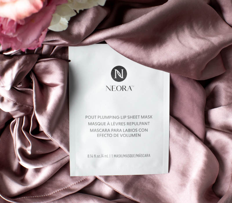 Producto de la Colección Especial Neora, Los Parches para Labios Hidratantes colocados en una seda y una flor
